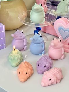 there are many small candles in the shape of animals next to a vase with a heart on it