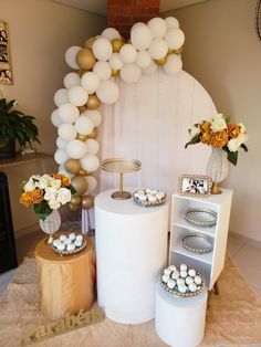 a table topped with lots of balloons and desserts next to a white cake stand