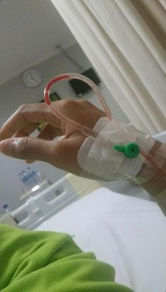 a person in a hospital bed with an iv tube wrapped around their arm and hand