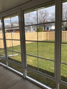 an open sliding glass door on the side of a house in front of a yard