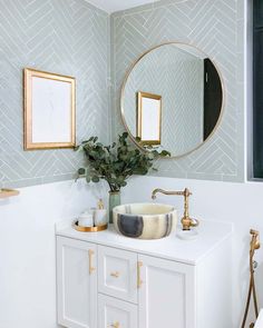 a bathroom with a sink, mirror and plant in the corner on the counter top