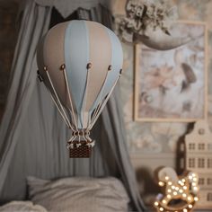 a blue and white hot air balloon hanging from the ceiling in a bedroom with lights