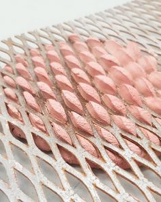 some pink and silver metal mesh on a white surface