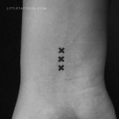 a black and white photo of a wrist with three crosses on it's side