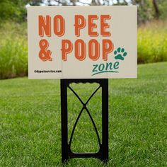 a no pee and poop sign in the grass