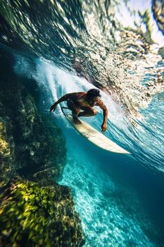 a man riding a surfboard on top of a wave in the ocean under water