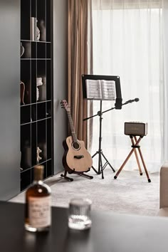 a living room with a guitar and music stand in the corner next to a window