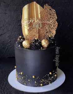 a black cake with gold decorations on top