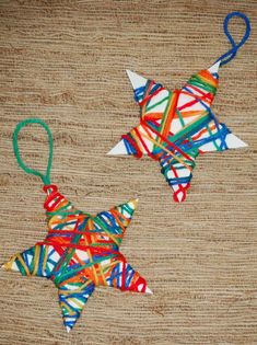 two christmas ornaments made out of strips of yarn on a tablecloth background, one is shaped like a star and the other has a string attached to an ornament