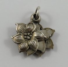 "This is a vintage mechanical \"Religious Flower Slider\" sterling silver charm for a charm bracelet. The flower has three layers and slides open to reveal an engraved picture on each side with flowers on the outside.  It weighs 3.90 grams and measures approx. 5/8\" x 3/4\", tested sterling silver. All charms come with a split ring to attach to a bracelet. We have hundreds of charms in stock. If you don't see what you are looking for in our shop please contact us as it is likely we have it. Inve Silver Flower Jewelry For Memorial, Vintage Jewelry With Flower Charm And Pendant, Collectible Silver Flower Jewelry, Vintage Flower Charm Pendant Jewelry, Antique Engraved Flower Jewelry, Antique Flower Engraved Jewelry, Silver Flower-shaped Locket Jewelry, Silver Flower Locket Jewelry, Silver Flower Shaped Locket Jewelry