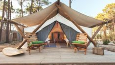 a large tent with two chairs and a surfboard on the ground in front of it