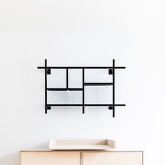 a cabinet with two drawers and a shelf on the wall above it that is mounted to the wall