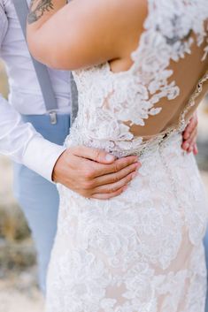 the bride and groom are holding each other close to their backs as they stand together