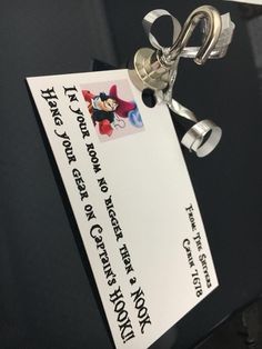 a close up of a key chain attached to a paper with a mickey mouse tag on it