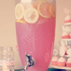 a pitcher filled with pink liquid and lemon slices