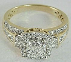 a yellow gold ring with two square cut diamonds on the sides and an intricate band around it