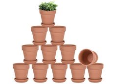 a pyramid of clay pots with a green plant in the middle