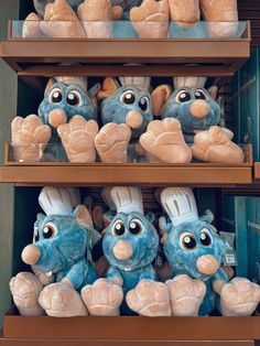 several stuffed animals are on shelves in a store, one is blue and the other is brown