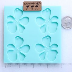 a cookie sheet with flowers on it and a penny sitting next to it in front of a ruler