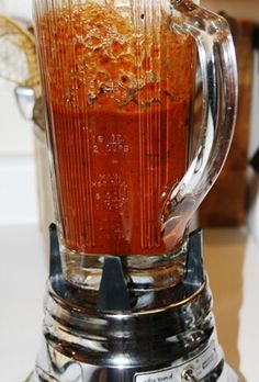 a blender filled with red liquid on top of a counter