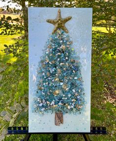 a painting of a blue christmas tree with starfish on it