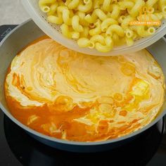 macaroni and cheese being cooked in a pot on top of the stovetop