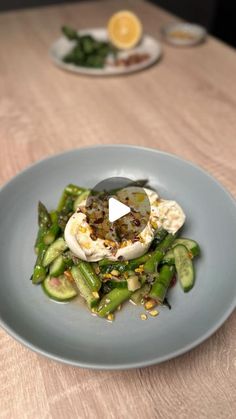 a blue plate topped with asparagus and an egg on top of another plate