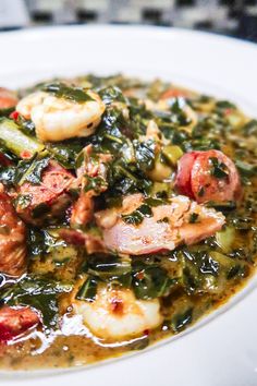 a white plate topped with shrimp and greens