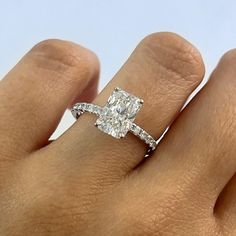 a woman's hand with a diamond ring on top of her finger and an engagement band