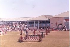 an open field with people standing around and onlookers in the back ground