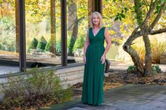 a woman in a long green dress standing outside