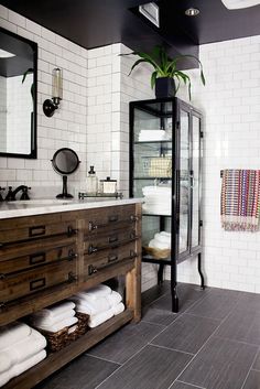 a bathroom with black and white tiles, wooden cabinets and drawers on the floor is shown