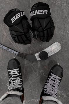 two pairs of black and white ice hockey gloves next to a goalie's mitt