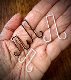 three small black and white musical notes are in the palm of someone's hand