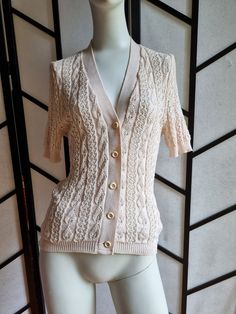 a mannequin is wearing a white sweater and cardigan