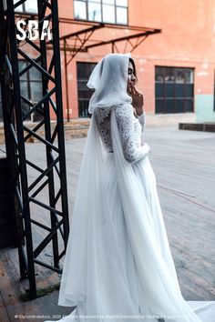 a woman in a white wedding dress is talking on her cell phone while wearing a veil