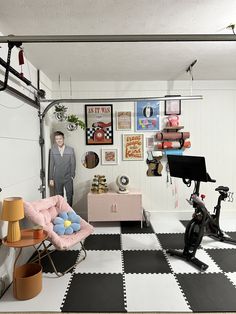 a man standing next to a bike in a room with black and white checkered floors