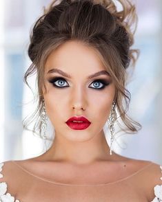 a beautiful woman with blue eyes and red lipstick wearing white lace on her wedding dress