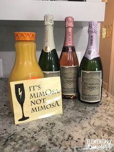 three bottles of wine sitting on top of a counter next to a sign that says it's mimos not mimosa