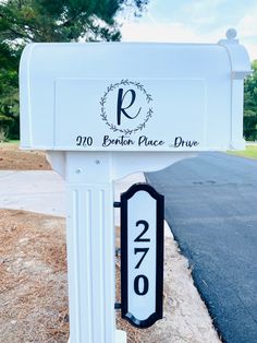 a white mailbox sitting on the side of a road