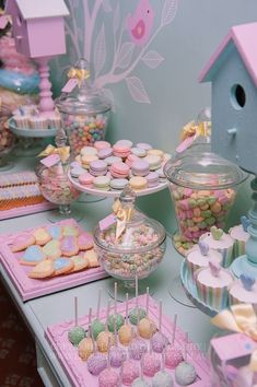 a table filled with lots of candy and candies next to a birdhouse on the wall