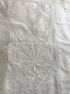 an old white quilt with many different designs on it