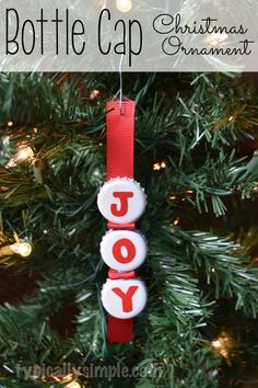 a bottle cap ornament hanging from a christmas tree with the words joy on it