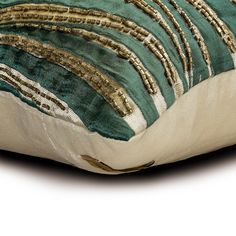 a green and gold striped pillow sitting on top of a white floor