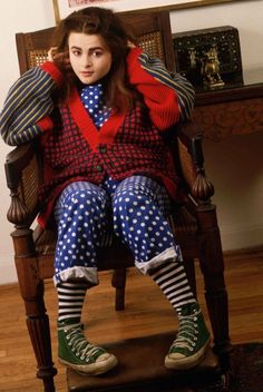 a woman sitting on top of a wooden chair wearing polka dot tights and socks