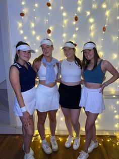 four girls in tennis outfits posing for the camera