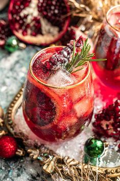 pomegranates in glasses with ice and rosemary sprigs on the rim