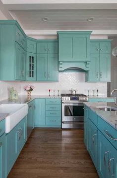 a kitchen with teal cabinets and white counter tops is pictured in this image from the front view