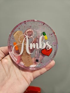 a person holding up a small plastic plate with some writing on it