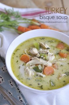 a white bowl filled with soup next to carrots and celery